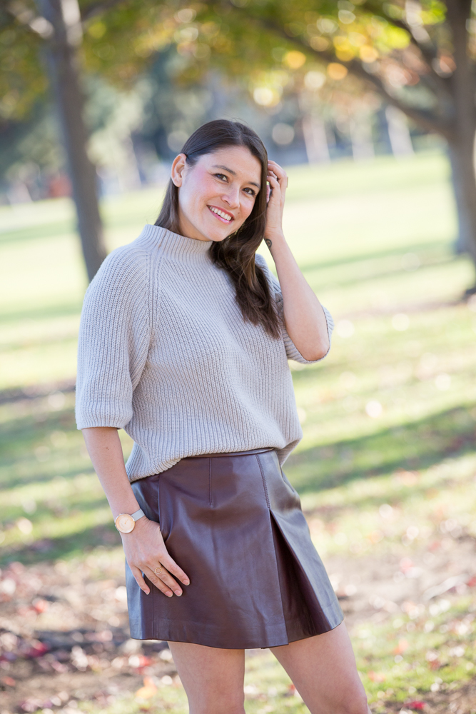 girl posing with sweater tucked into a skirt